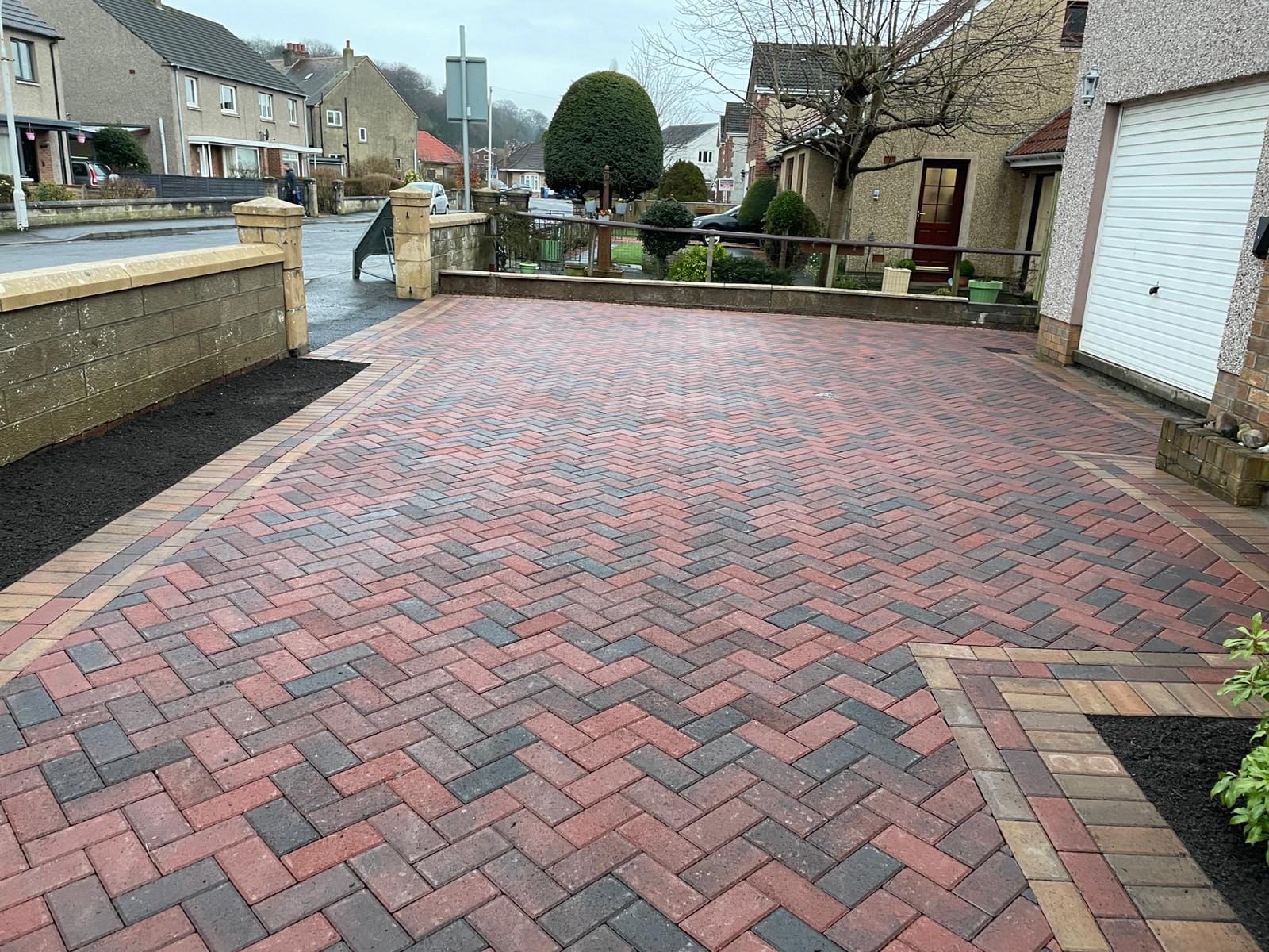 Large red and grey herringbone block paving driveway