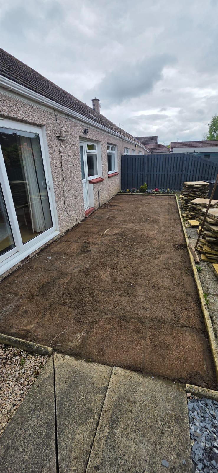Raised flagstone patio with block paving steps and turf